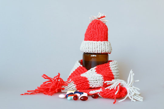 a bottle of syrup dressed in a scarf and cap in the season of colds