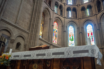 Low angle of bible on wooden table on concrete wall with beautiful mosaic windows background in...