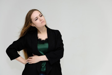 Obraz premium Concept portrait for the waist of a pretty girl, a young woman with long beautiful brown hair and a black jacket and blue jeans on a white background. In studio in different poses showing emotions.