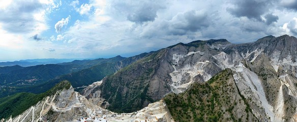 Obraz premium Aerial view of mountain of stone and marble quarries in the regional natural park of the Apuan Alps located in the Apennines in Tuscany, Massa Carrara Italy. Open pit mine