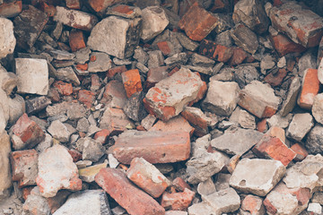 Pile of broken bricks, background. Texture, pattern, brick wall collapse. Destruction surface of building's facade. Debris. 