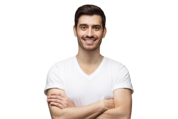 Obraz premium Smiling handsome man in casual t-shirt standing with crossed arms isolated on white background