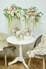 Luxury floral arrangement of pink and white flowers in glass vases on wood table, copy space. Wedding decorations, holiday concept