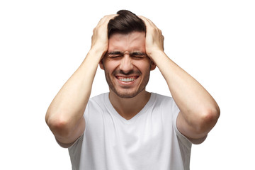People, stress, tension and migraine concept. Upset unhappy young man squeezing head with hands,...