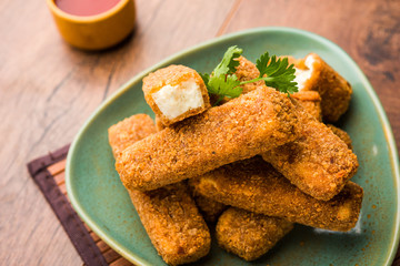 Kurkuri paneer fingers or pakora/pakoda snacks also known as Crispy Cottage Cheese Bars, served with tomato ketchup as a starter. selective focus