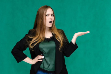 Concept portrait for a belt of a pretty girl, young woman with beautiful brown hair and in a black jacket and green T-shirt on a green background. In the studio in different poses showing emotions.