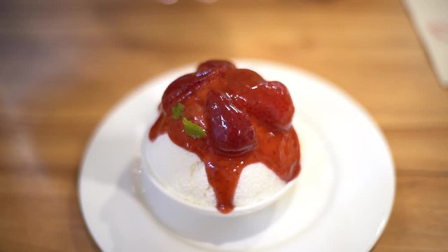 Pouring sauce to Ice milk Korean dessert, bingsu with strawberry 