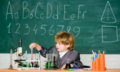 Boy near microscope and test tubes in school classroom. Kid study biology chemistry. Knowledge day. Basic knowledge primary school education. Happy childhood. Child enjoy studying. Knowledge concept