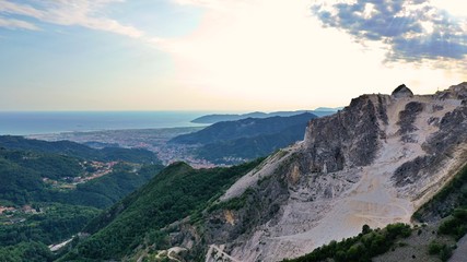 Naklejka premium Aerial view of mountain of stone and marble quarries in the regional natural park of the Apuan Alps located in the Apennines in Tuscany, Massa Carrara Italy. Open pit mine