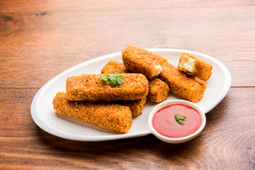 Kurkuri paneer fingers or pakora/pakoda snacks also known as Crispy Cottage Cheese Bars, served with tomato ketchup as a starter. selective focus