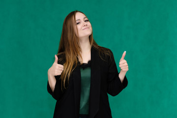 Concept portrait for a belt of a pretty girl, young woman with beautiful brown hair and in a black jacket and green T-shirt on a green background. In the studio in different poses showing emotions.