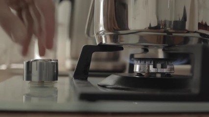 Close up of hand turns gas stove on and then turns it off on kitchen 