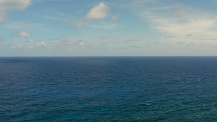 Surface of blue ocean with waves and blue sky with cloud, aerial view. Water cloud horizon background. Blue sea water with waves against sky.