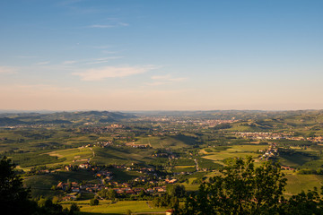 Panoramic view of the vineyard hills in the  Langhe area, Unesco World Heritage Site since 2014, with the city of Alba in the valley in the background, Cuneo, Piedmont, Italy