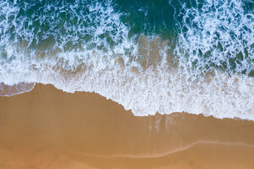 Aerial view of Blue ocean wave on sand beach.