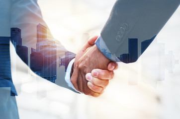 Welcome. double exposure image of investor business man shaking hands with partner for successful...