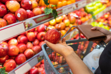 Woman hand holding an fresh apple at fruit store