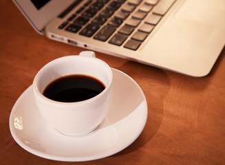 Obraz na płótnie Canvas Laptop keyboard with coffee cup