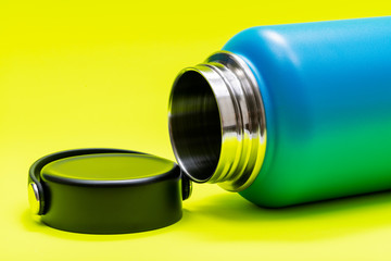 Blue Wide Mouth Insulated Stainless Steel Bottle with Wide Flat Cap isolated on bright yellow background. BPA-Free. Double Wall Vacuum Insulation.