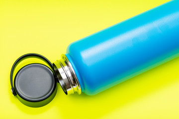 Blue Wide Mouth Insulated Stainless Steel Bottle with Wide Flat Cap isolated on bright yellow background. BPA-Free. Double Wall Vacuum Insulation.