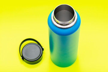 Blue Wide Mouth Insulated Stainless Steel Bottle with Wide Flat Cap isolated on bright yellow background. BPA-Free. Double Wall Vacuum Insulation.