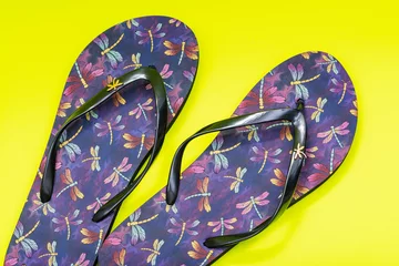 Foto op Plexiglas Purple Beach Day Flip Flops with dragonfly pattern isolated on bright yellow background. © bjphotographs