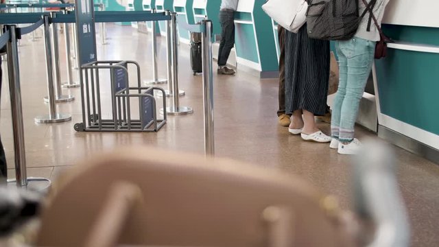 Several passengers standing in queue while waiting for check-in registration