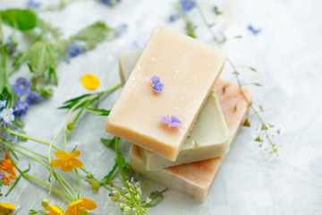 Natural handmade soap bars with organic medicinal plants and flowers.Homemade beauty products with natural essential oils from plants and flowers, top view closeup photo - 279521100