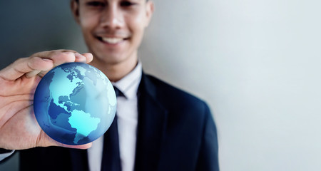 Globalization Concept. Happy Smiling Professional Businessman holding a Transparent Blue World Globe in Hand