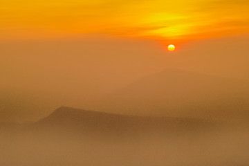 Fototapeta na wymiar Mountain view morning of top hill around with soft fog and yellow sun light in the sky background, sunrise at top of Phu Ruea National Park, Phu Ruea District, Loei Province, Thailand.