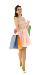 Teenager girl shopping in a store with large paper bags.