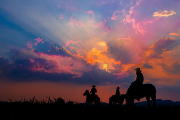 Fototapeta na wymiar Cowboy on horseback with views of the mountains and the sunset sky.