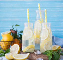 Homemade lemonade with lemon, mint and ice in bottles