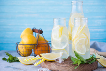 Homemade lemonade with lemon, mint and ice in bottles