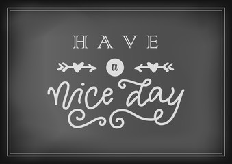 Fototapeta na wymiar Modern calligraphy lettering of Have a nice day in white with arrows and hearts on chalkboard background