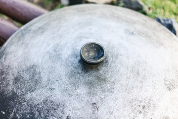 Cauldron lid on a wooden bench. Close-up image of a metal caldron lid.