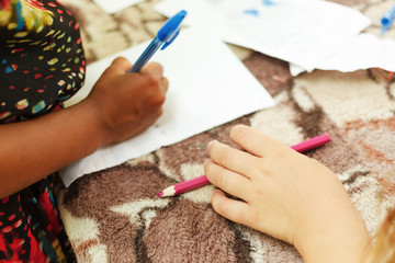 Writing a letter. Little girl writing a letter to her parents. Close up of the girl's hand with a pen.
