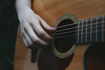 Fototapeta premium Acoustic guitar close-up. Man's hand playing guitar. Musician concept.