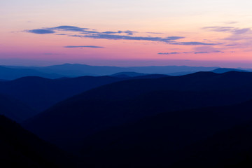 Fototapeta premium Majestic sunset in the mountains landscape. Beautiful landscape with high mountains blue sky and pink sunlight in sunset. Carpathian Mountains.
