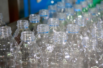Close up of the plastic bottle in the conveyor belts. The PET bottles in the drinking water plant.