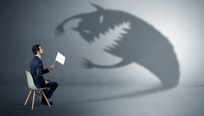 Young businessman staying and negotiate with a monster shadow