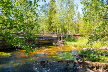 Obraz na płótnie Canvas Summer view of the rapids in Äkäsmylly, wooden bridge, river and nature, Muonio, Finland