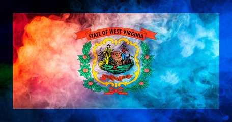 The national flag of the US state West Virginia in against a gray smoke on the day of independence in different colors of blue red and yellow. Political and religious disputes, customs and delivery.