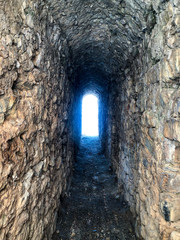 Tunnel arched hole in the stone wall of the fortress.