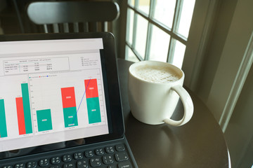businessman using Smartphone and tablet for analysis graph visualization at coffee shop