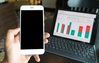 businessman using Smartphone and tablet for analysis graph visualization at coffee shop