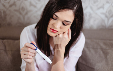 Barren young woman sad when she sees a negative pregnancy test