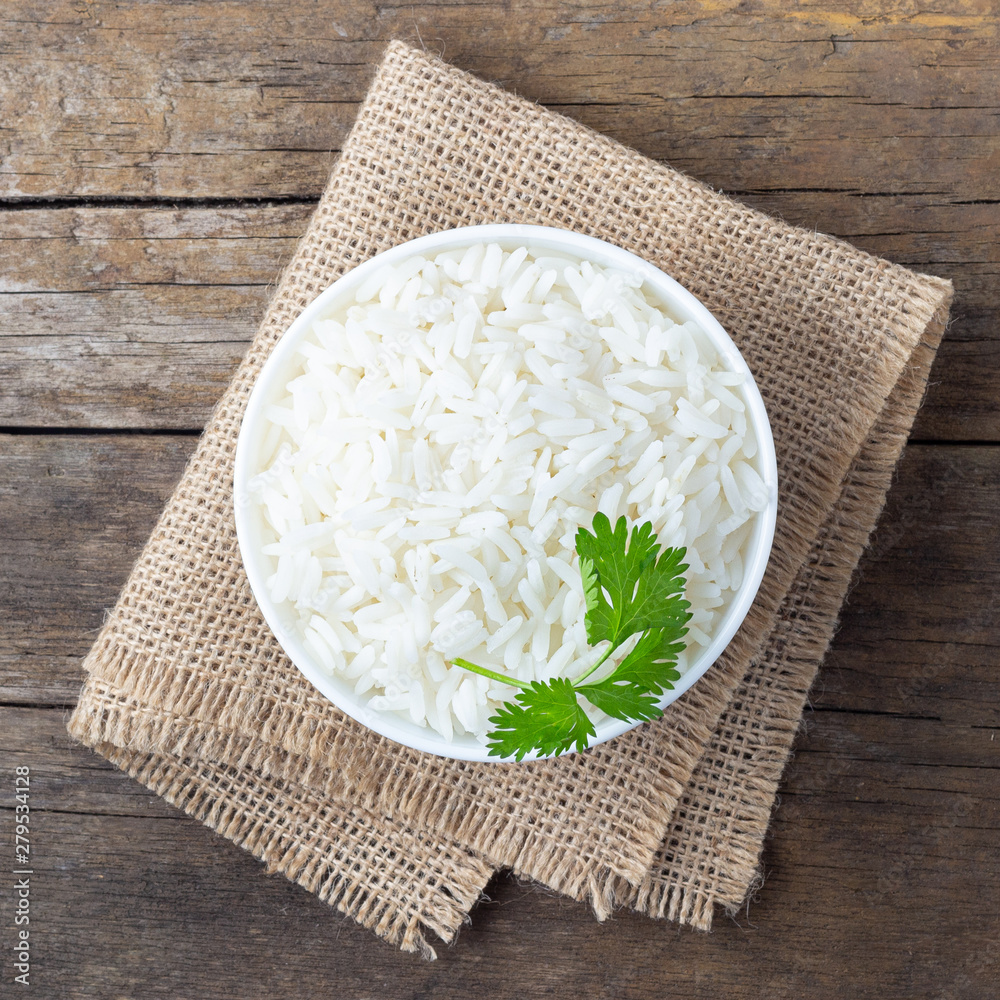 Wall mural boiled rice in a bowl on wooden rustic table.