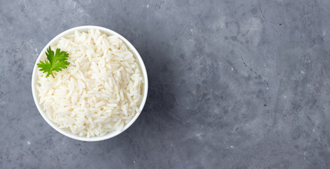 Boiled rice in a bowl on gray stone background. Top view with copy space.