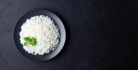 Fototapeten Steamed rice on black plate. Black stone background. Top view with copy space. © Dmitrii